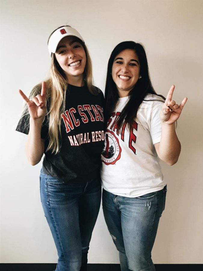 Current and future classmates Cassidy Grosz  and Alyssa Tangradi throw wolf signs to their future wolfpack classmates.