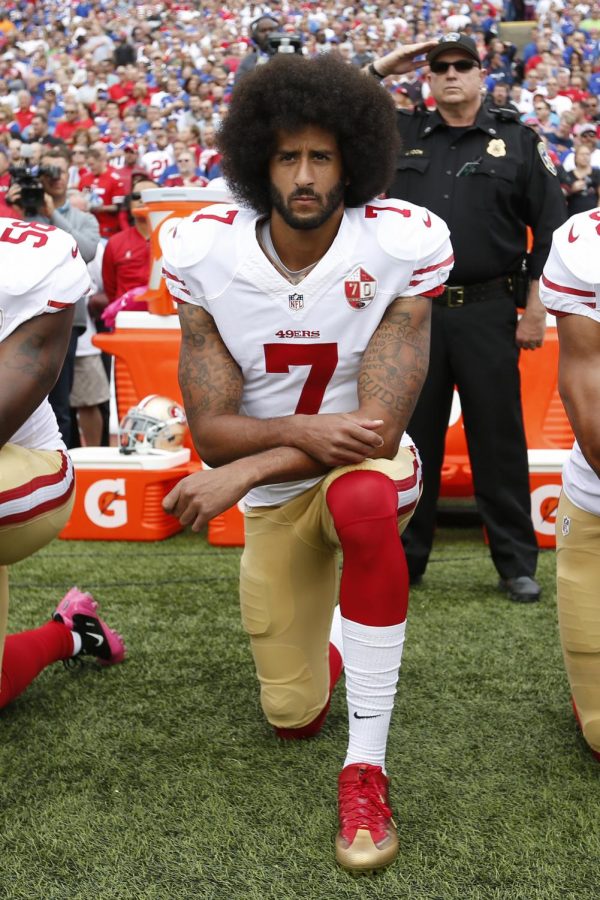 San Francisco 49er’s quarterback Colin Kaepernick protests during the National Anthem.