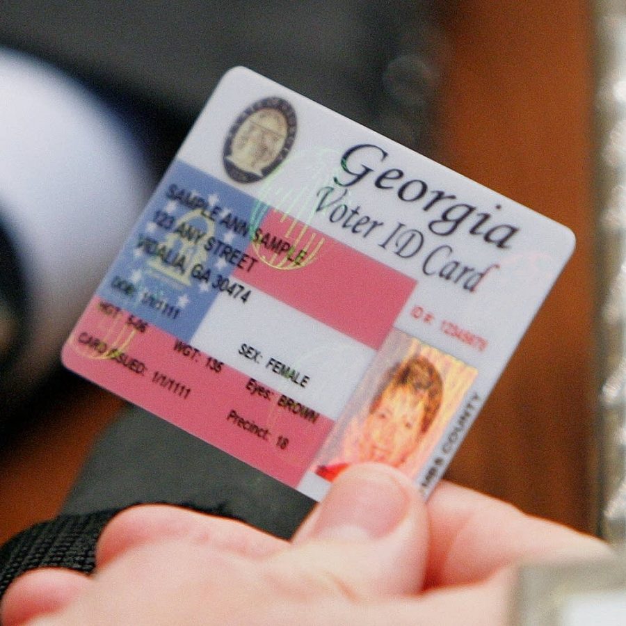 Sen. Bill Stephens, R-Canton, looks at a sample of a proposed new secure Voter ID as the Senate takes up Voter ID legislation, SB84, House Substitute as Amended, on the floor of the Senate Tuesday, Jan. 24, 2006. (AP Photo/Ric Feld)