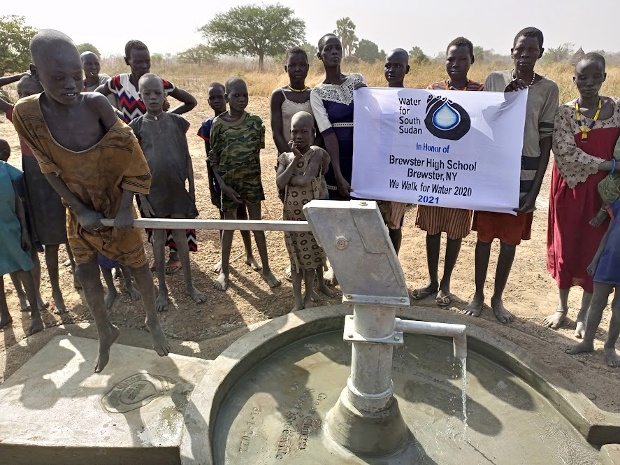Families celebrate the first time they have fresh well water in their town. 